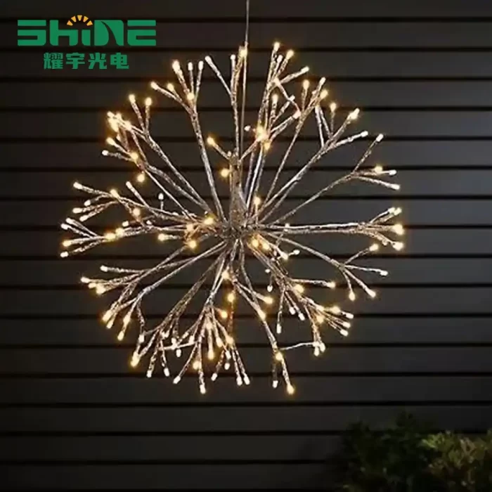 LED fireworks lights which is warm light hang from the dark slatted wall, creating a festive outdoor decoration atmosphere. The "SHINE" logo is printed on the upper left corner.