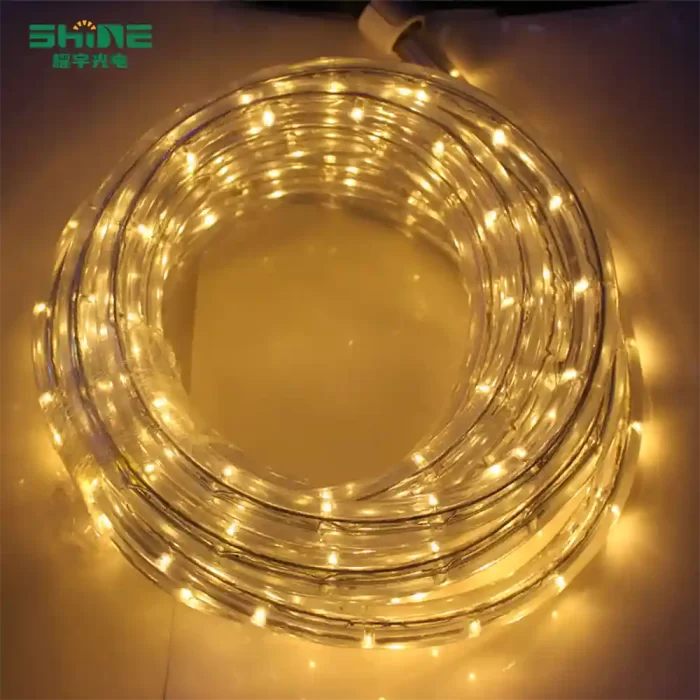 LED string lights coiled in a clean layout on white floor tiles, showing warm yellow tones without a central support.