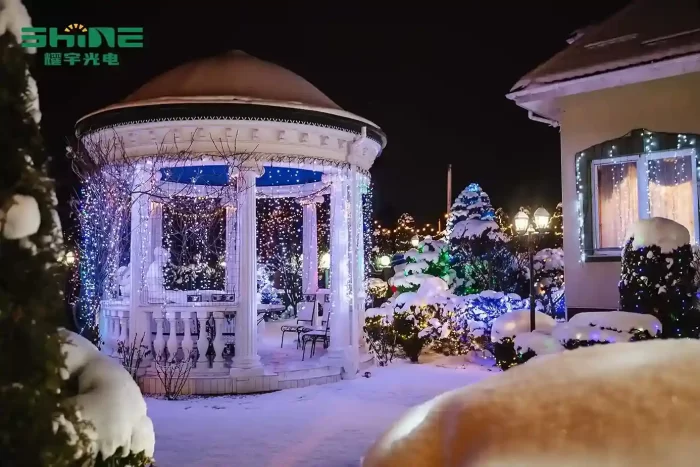 Snowy garden decorated with festive lights, creating a winter wonderland.