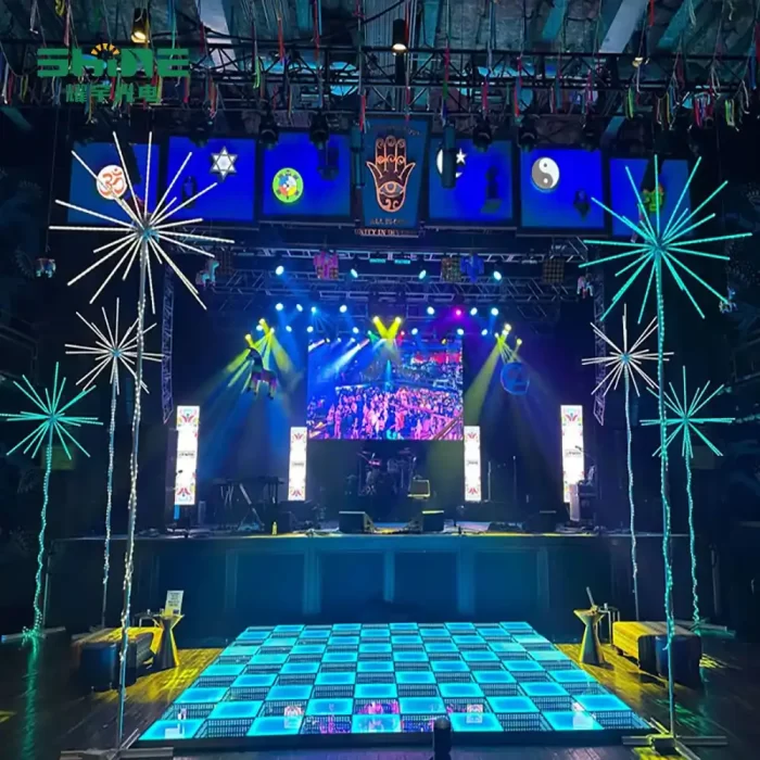 Stunning blue-toned LED string lights for weddings arranged in a firework pattern frame the dance floor and stage at a wedding celebration with dramatic lighting effects.