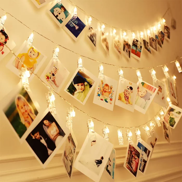 photo display lights stretch across a bright white wall, softly framing a cherished family portrait and filling the living room with a warm, welcoming atmosphere