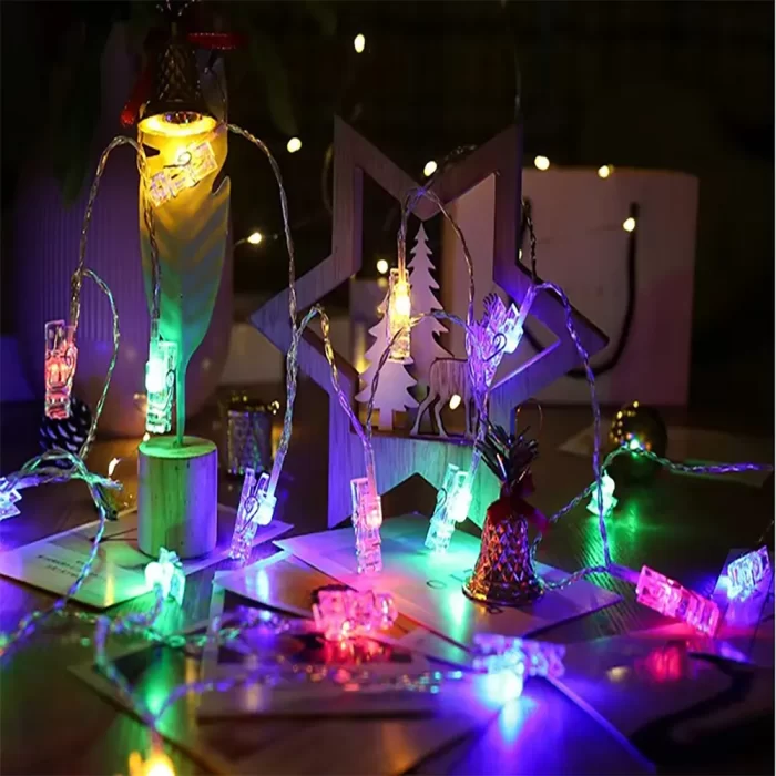 photo display lights glow with vibrant colors, illuminating Christmas cards and wooden decorations at night for a joyful holiday vibe