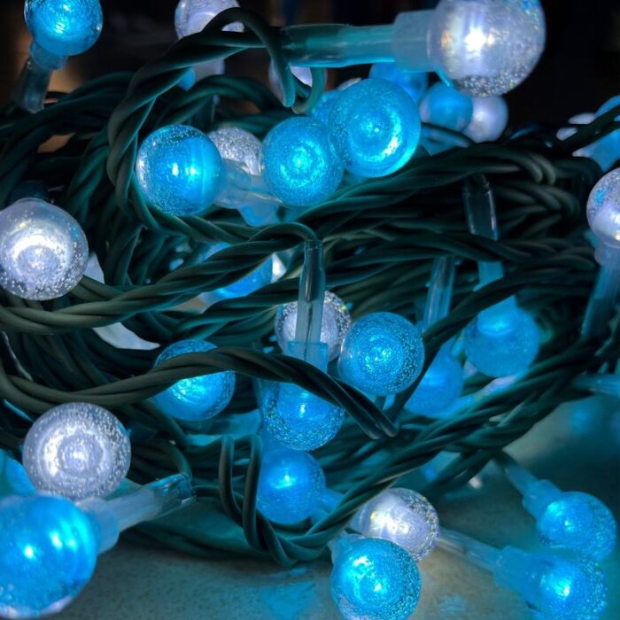 LED fairy lights for bedroom featuring blue globe string lights with green wires; battery-operated to create a charming and romantic ambiance.
