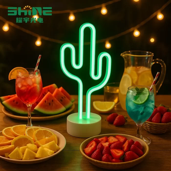 Cactus neon light on summer party table with cocktails, fruit platters and festive string lights
