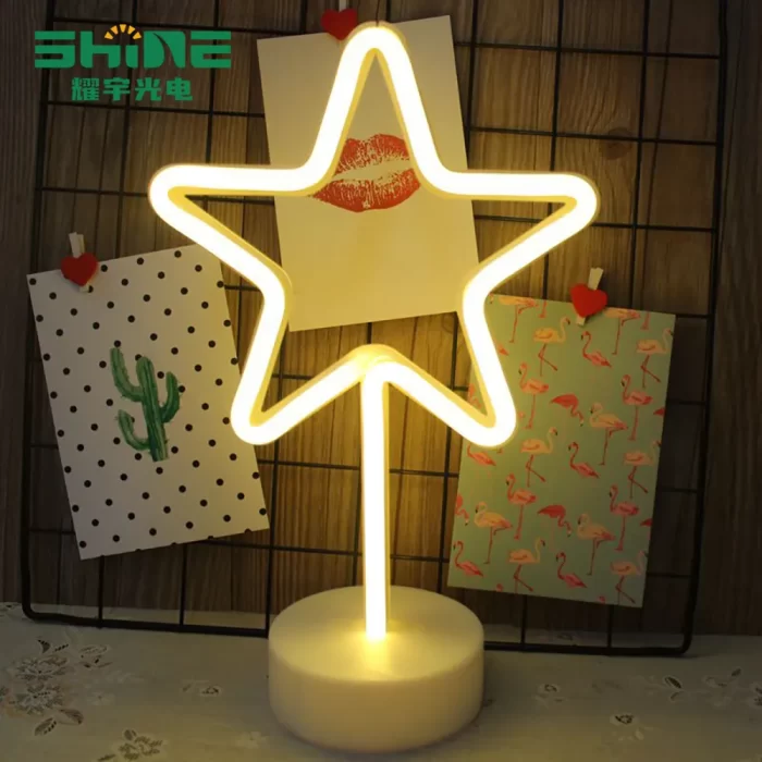 Star neon sign in warm white beside postcards, creative lighting for gift shops and festive retail displays.