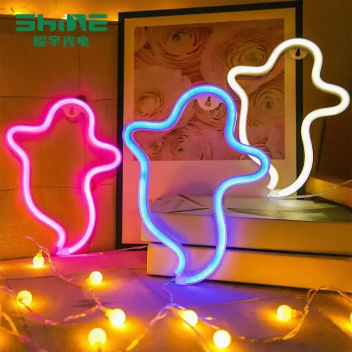 Pink, blue, and warm white ghost neon signs on bookshelf with warm string lights – Halloween décor