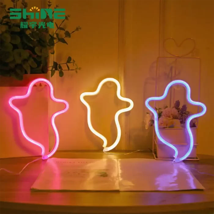 Ghost neon signs in pink, yellow, and blue on a table – party and shop window decoration