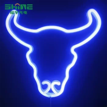 Letrero de neón con forma de cabeza de toro en una pared oscura que brilla en azul.