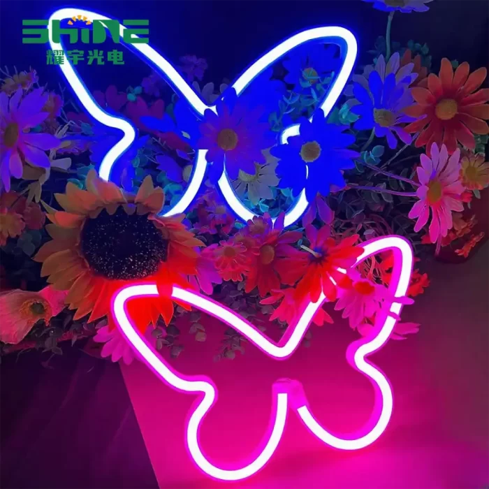 Twin butterfly neon lights in pink and blue, decorative wall signs for seasonal retail displays.
