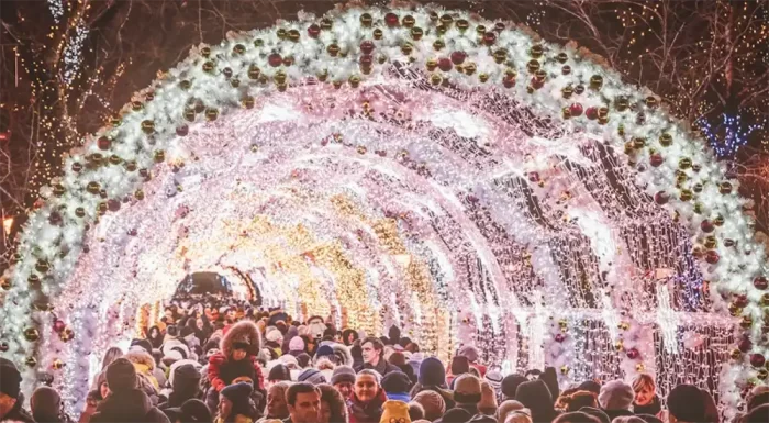 Crowd enjoying a 3D LED motif arch tunnel filled with bright holiday lights