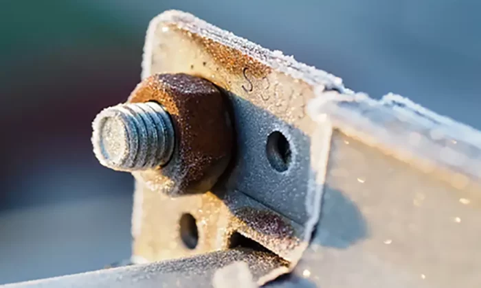 A close-up image of a steel fastener showing signs of rust and corrosion, demonstrating the risks of exposed metal components in outdoor environments.