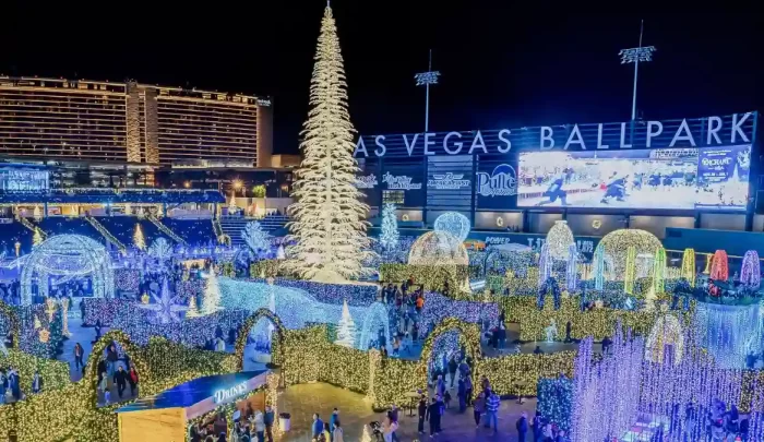 Overview of a large Christmas light festival at Las Vegas Ballpark with 3D trees, tunnels, ornaments and crowds, illustrating a multi-container large-scale lighting project.
