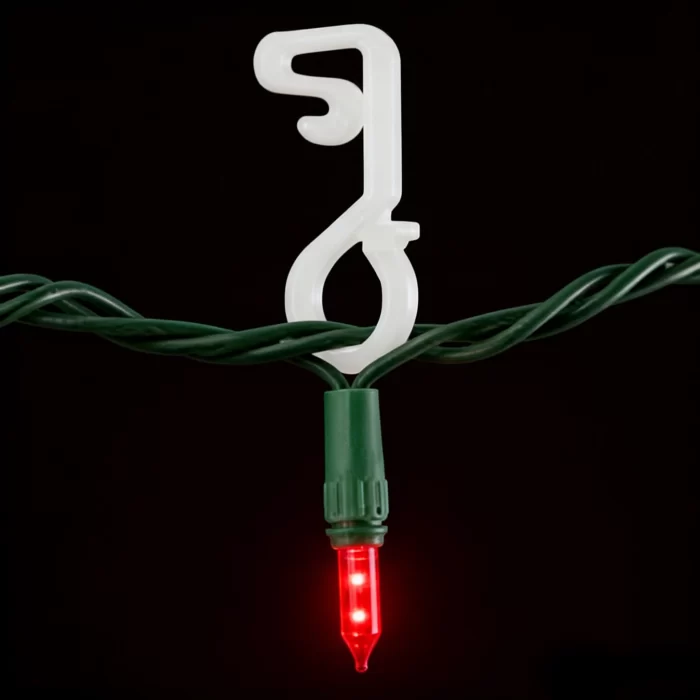 Plastic Christmas light clip securing a mini LED on green wire for a neat roofline or gutter installation.