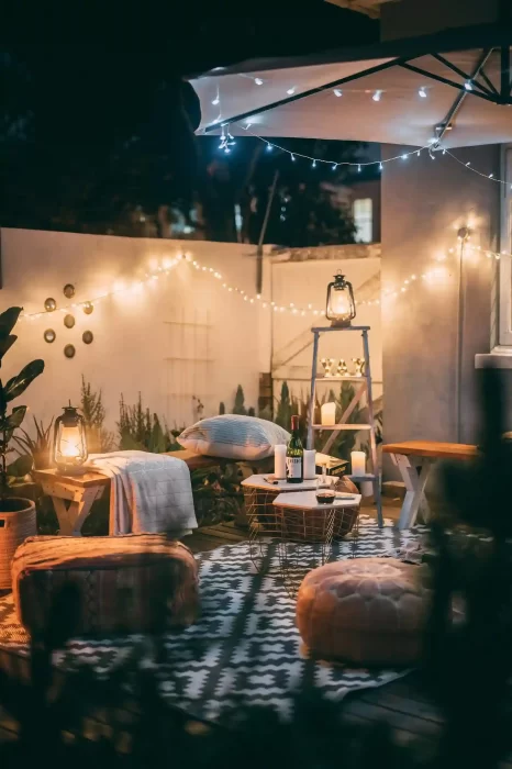 Cozy backyard lounge lit by outdoor Edison bulb string lights at night
