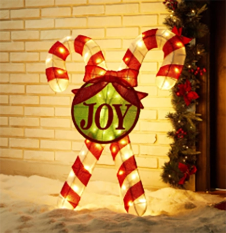 Large illuminated candy canes with a "JOY" sign, perfect for outdoor Christmas decorations.
