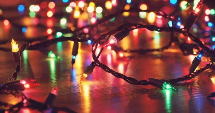Multicolor mini string lights on a wooden floor, close-up detail