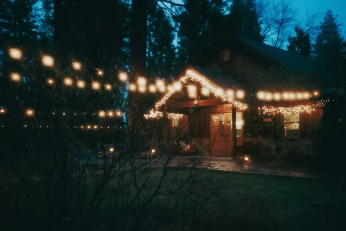 Warm white roofline string lights on a cabin at dusk