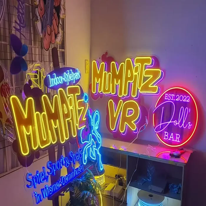 Multiple neon signs in a studio display repeated typography and lighting motifs, demonstrating consistent brand identity touchpoints