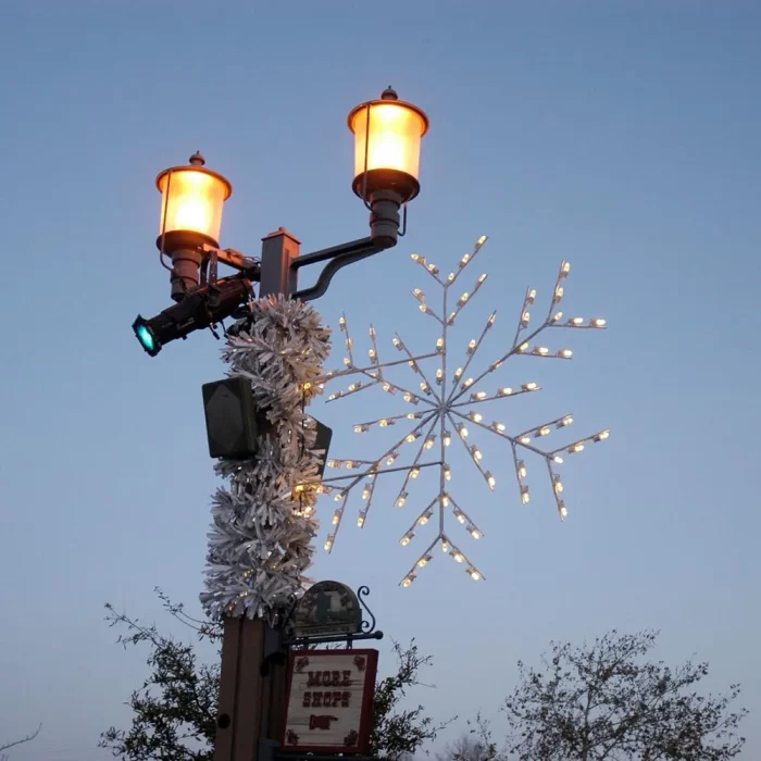 Street lamp post with mounted snowflake LED motif showing a typical municipal installation position