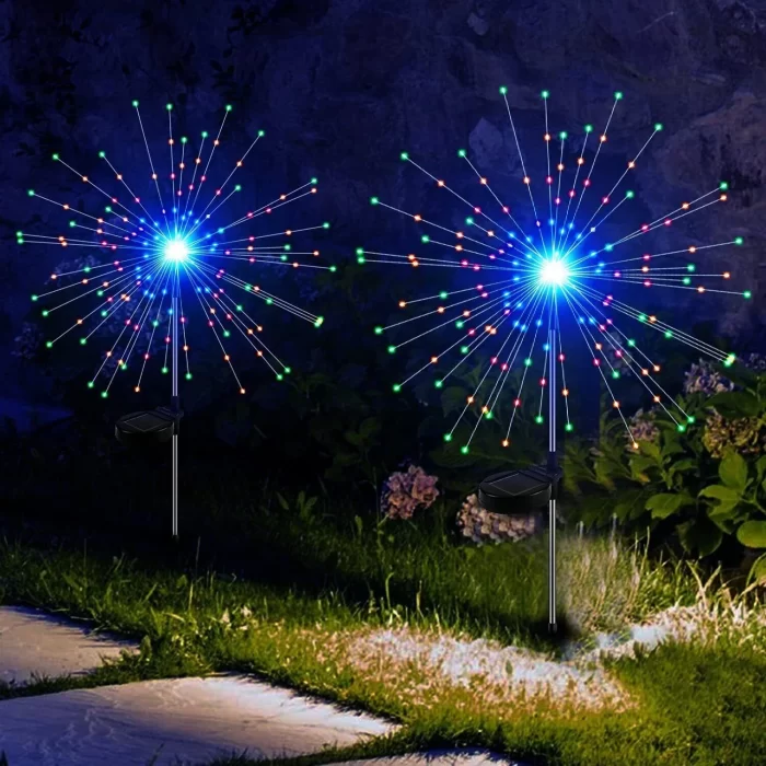 Solar firework Christmas lights glowing in a garden at night with colorful starburst LEDs
