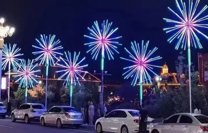 Commercial LED firework lights installed along a city street, showing pole-mounted RGB starburst fixtures for public holiday decoration.