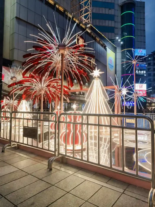 Outdoor LED firework lights decorating a shopping street facade with bright red and white starburst fixtures